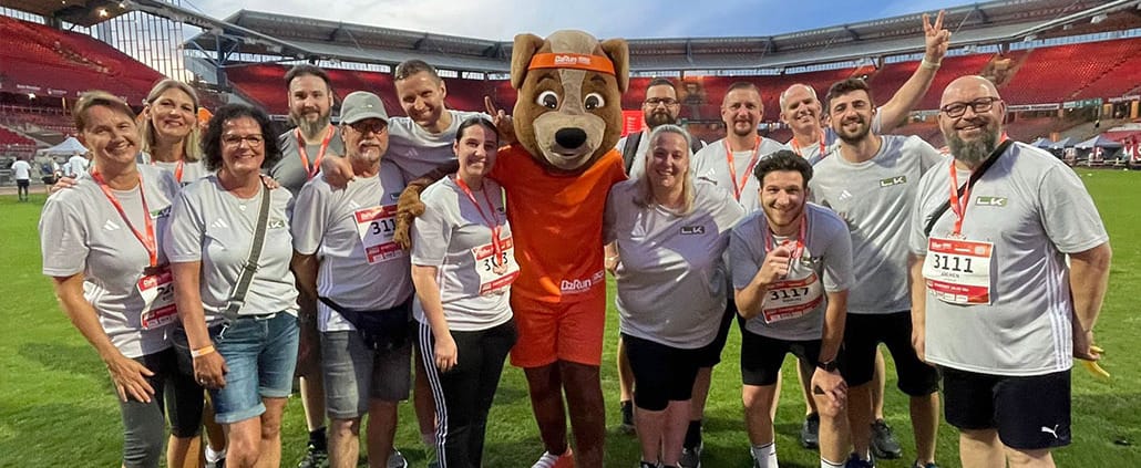 LK Metall employees pose with the B2Run mascot in the Max Morlock Stadium