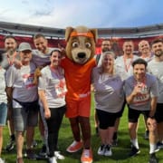 LK Metall employees pose with the B2Run mascot in the Max Morlock Stadium